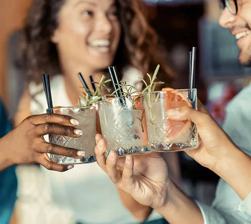 Tre personer som skåler en drink