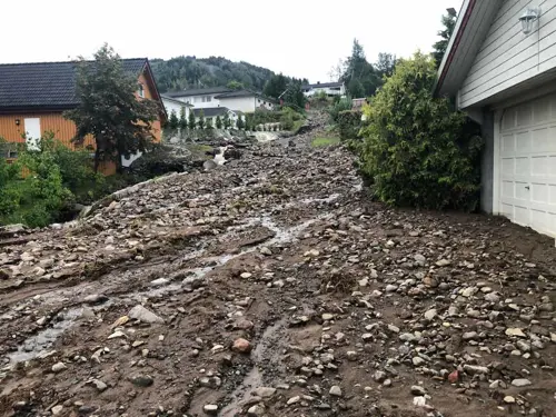 Bilde av flomskade i et nabolag hvor det bare er stein igjen og vannet har vasket bort overflaten