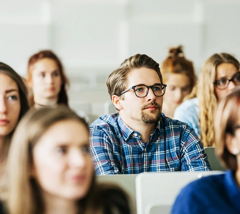 Ung mann følger med i forsamling