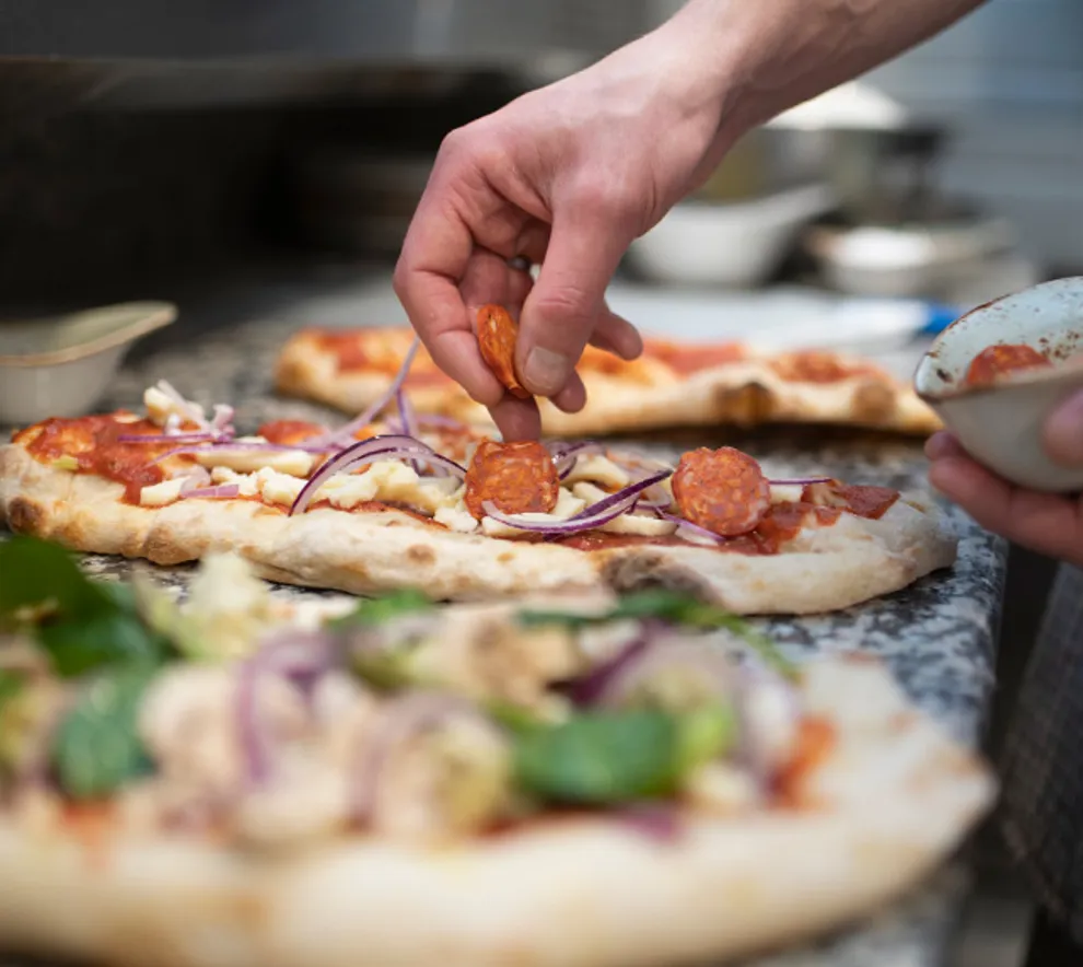 Persob som lager pizza