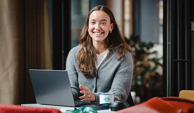 Kvinne_smiler_ved_datamaskin.wide-01815_640x372.jpg
