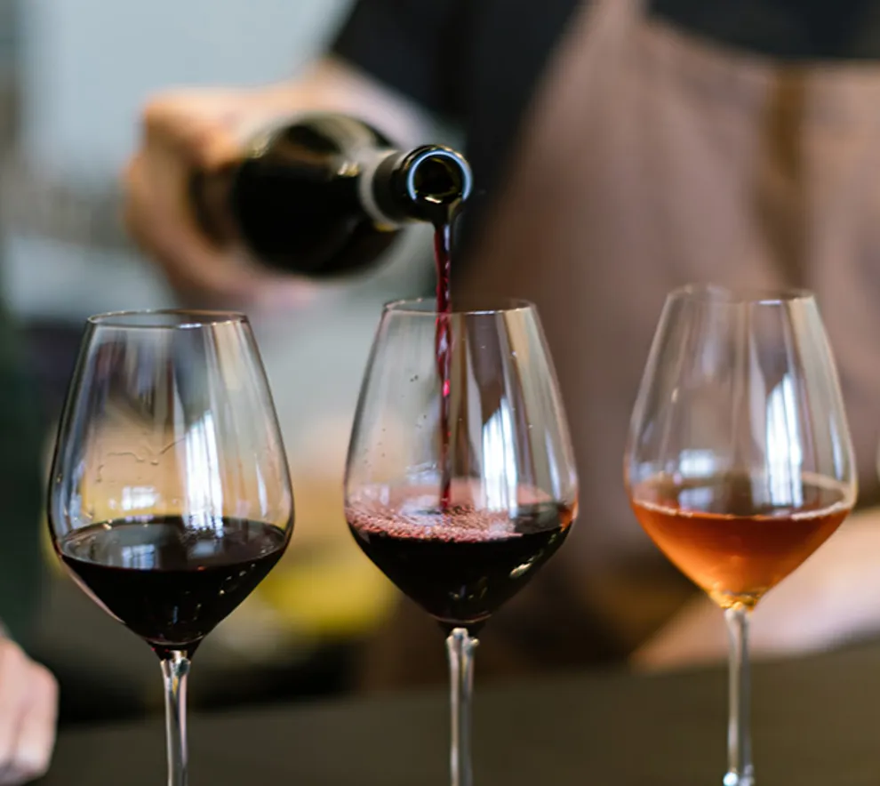 Person som heller vin i vinglass