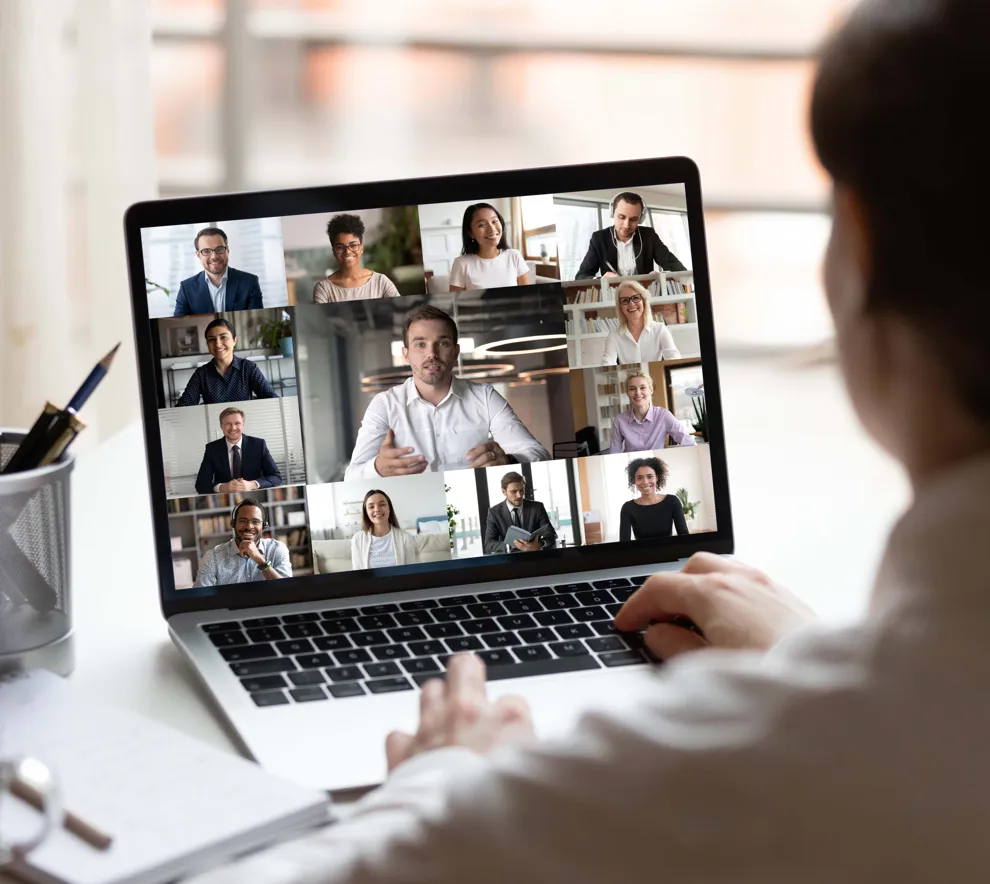 Dame som sitter ved en datamaskin i et digital møte