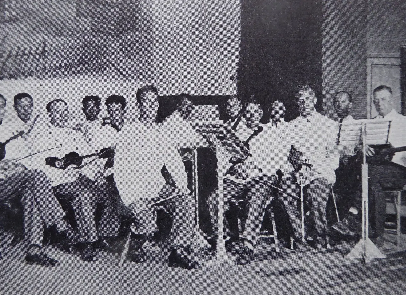 En gruppe menn i hvit sittende med instrumenter
