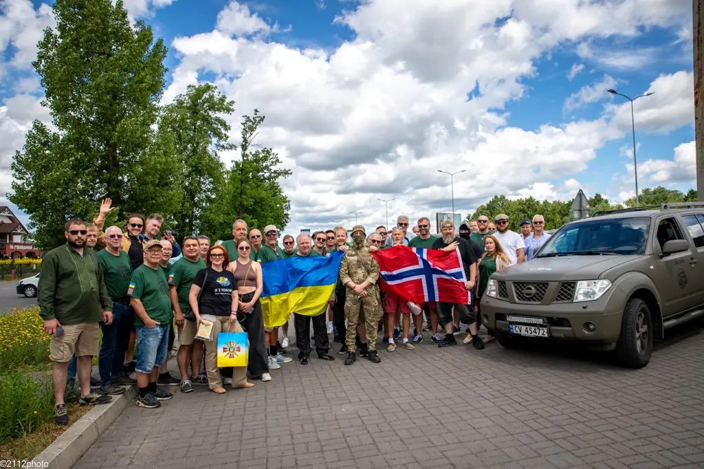 Stor gruppe mennesker med norsk og ukrainsk flagg