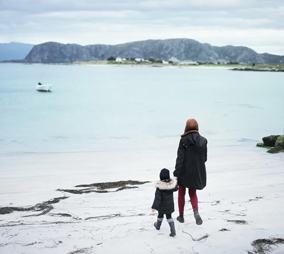Voksen og barn på en strand