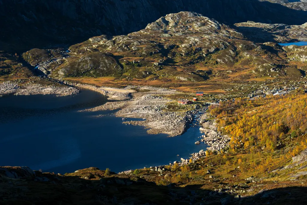 Dronebilde av rød hytte i fjell-landskap