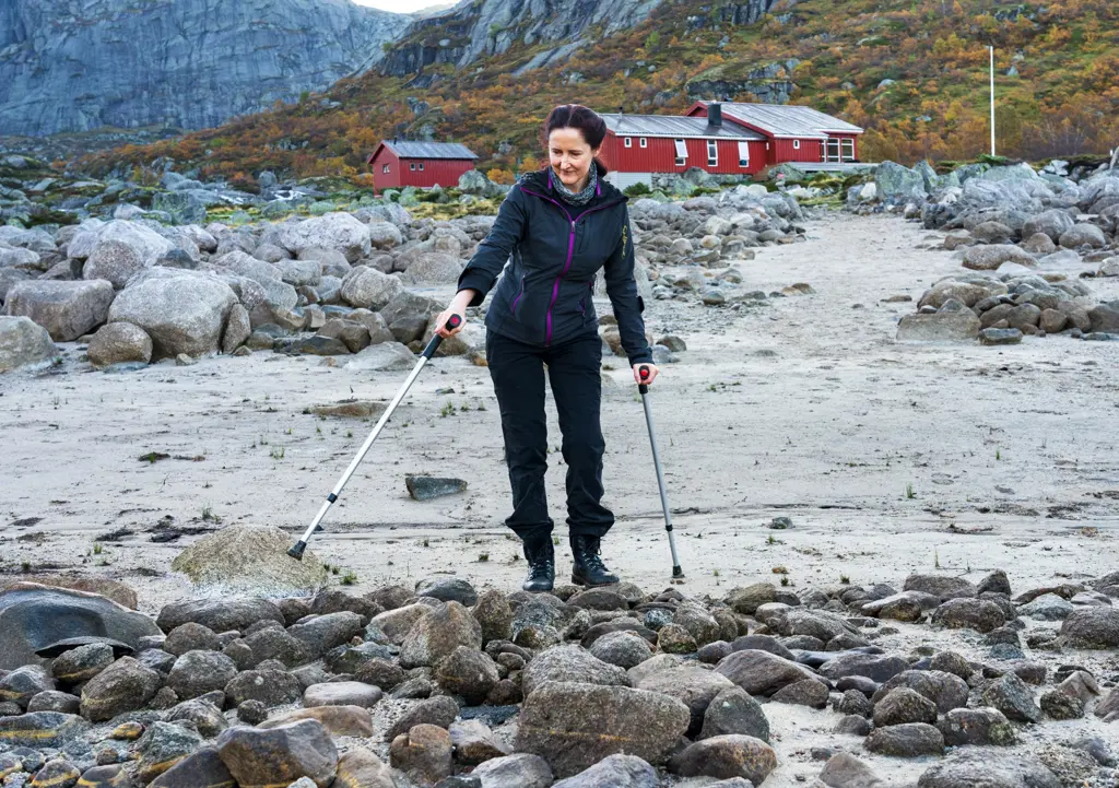 Kvinne med krykker og rød hytte bak2