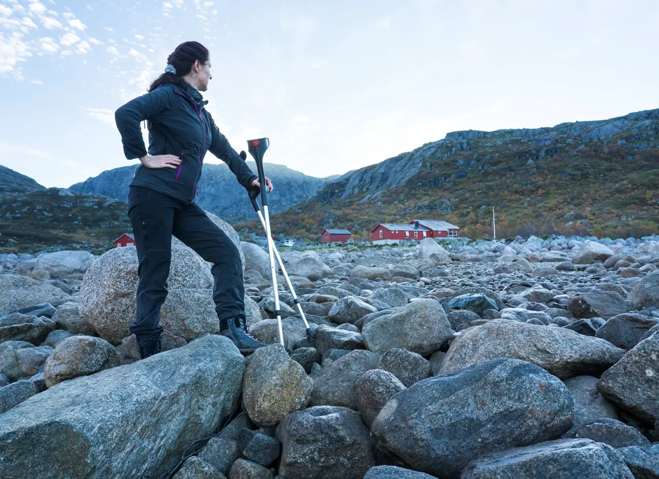 Kvinne blant rullestein ser bakover