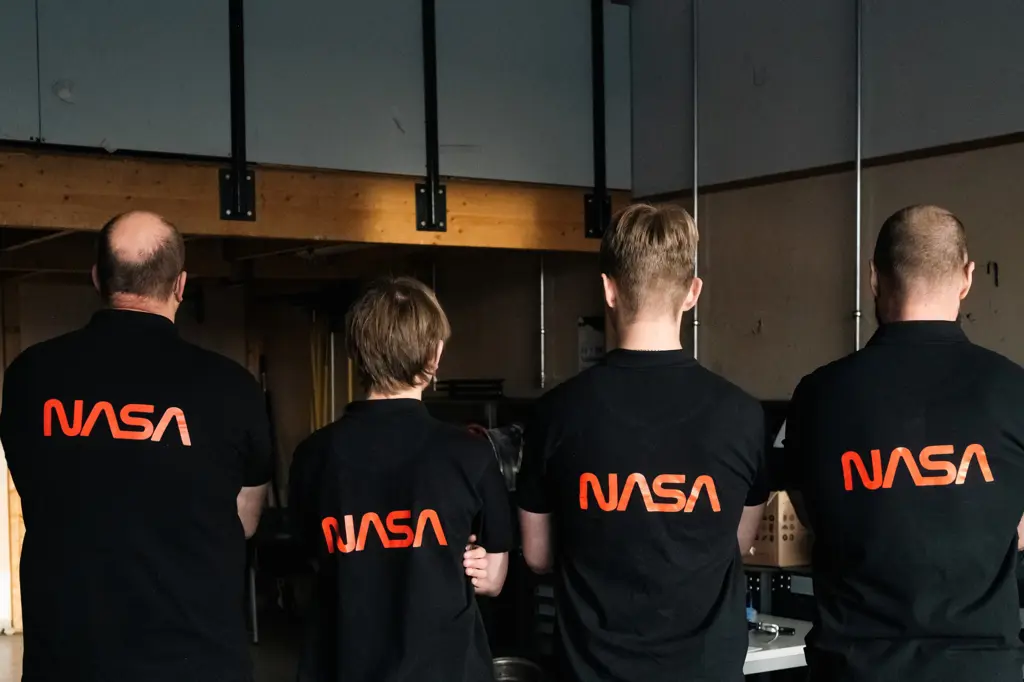 4 personer med ryggen til i NASA -t-skjorter