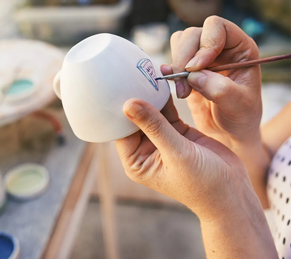 Person som maler på kopp