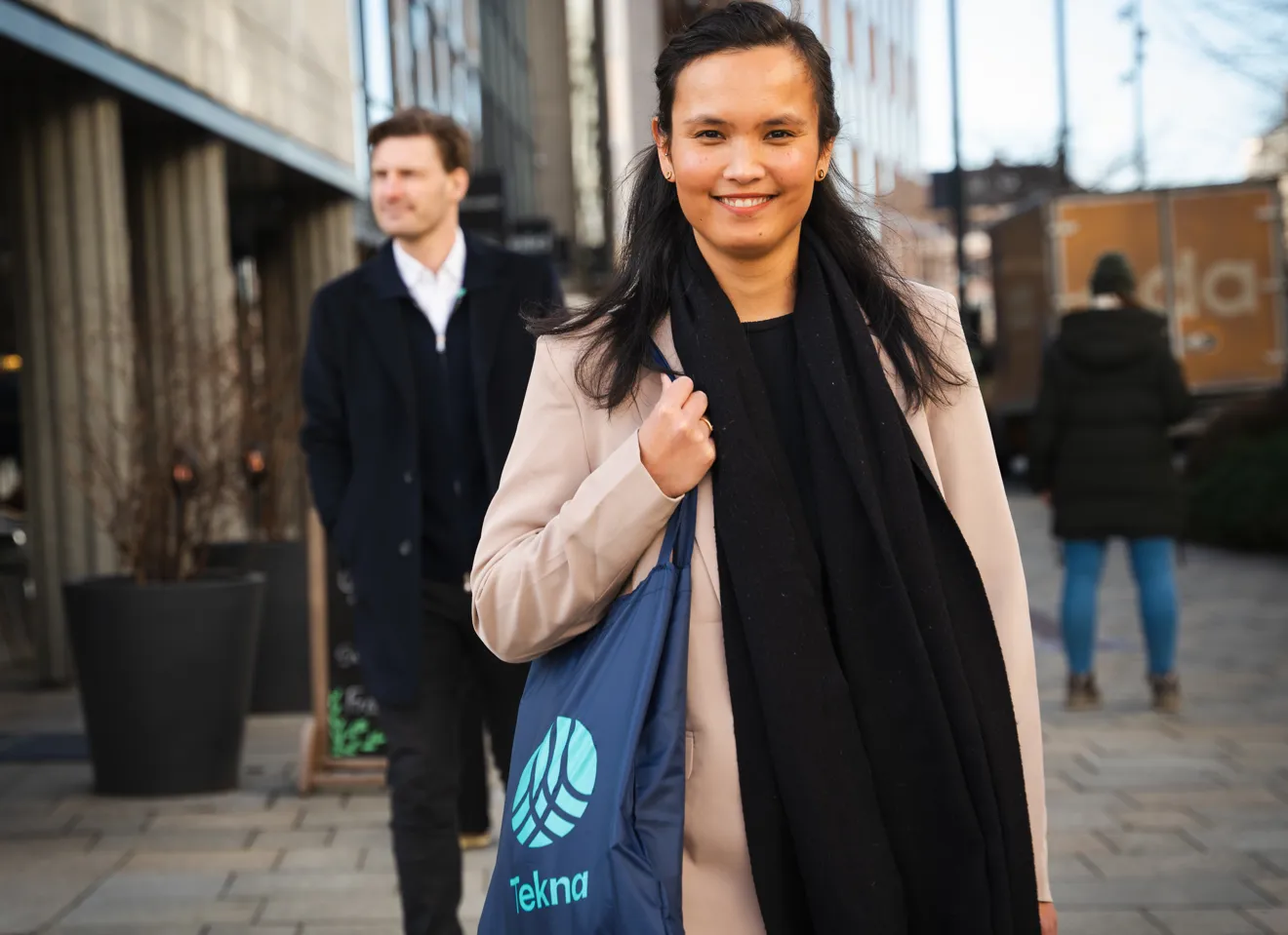 Kvinne med Tekna-veske og mann i bakgrunnen