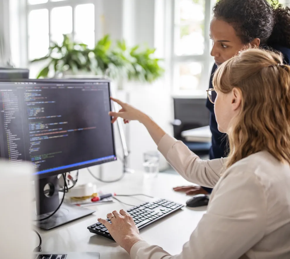 To kvinner foran en pc skjerm