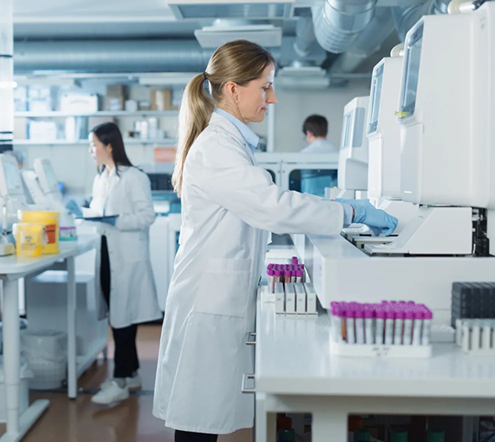 Laboratoriepersonell analyserer prøver med avansert medisinsk utstyr i et moderne laboratorium.